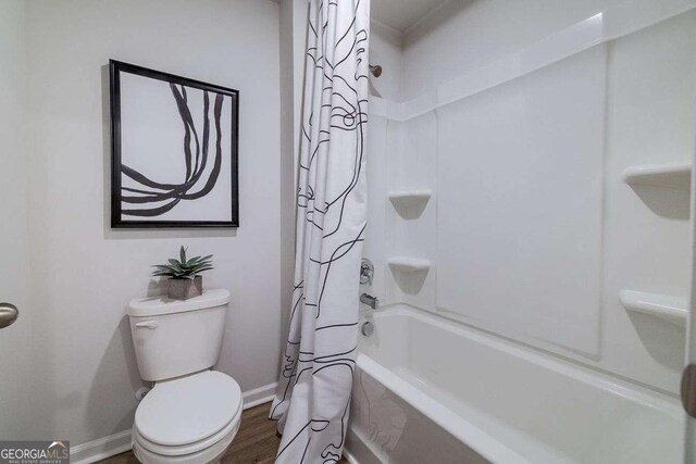 bathroom featuring wood-type flooring, toilet, and shower / bath combo