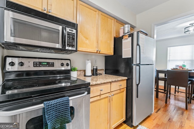 kitchen featuring light brown cabinetry, light hardwood / wood-style floors, and appliances with stainless steel finishes