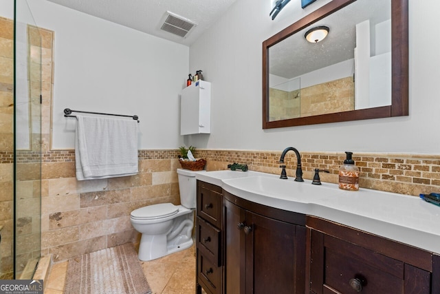 bathroom with tile walls, vanity, and toilet