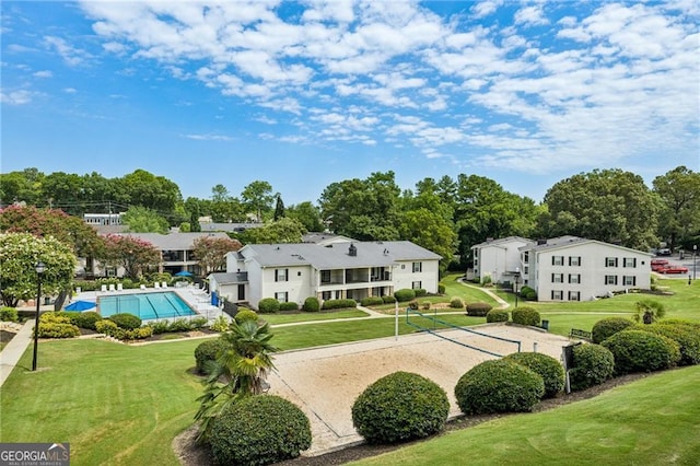 exterior space with a pool, a yard, and volleyball court