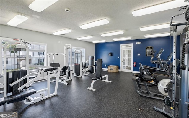 gym with french doors and a textured ceiling