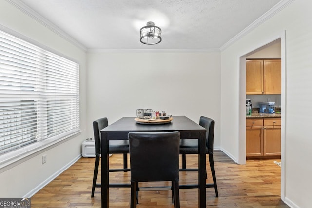 dining room featuring crown molding and light hardwood / wood-style floors