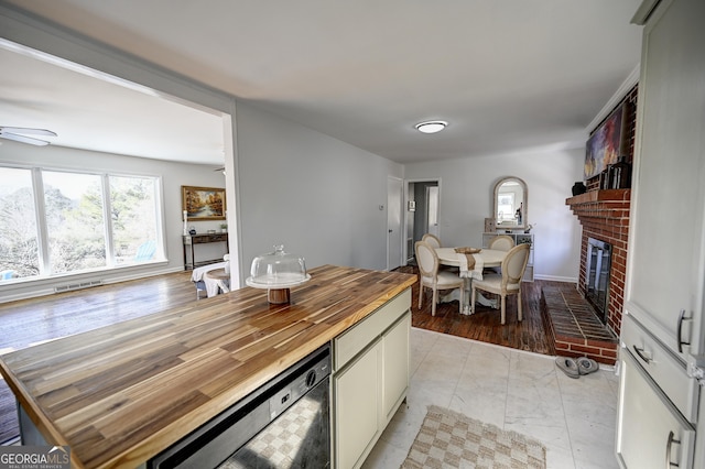1202 Franklin Rd SW, Plainville, GA 30733 - kitchen featuring butcher block counters, light marble finish flooring, a ceiling fan, a fireplace, and plenty of natural light
