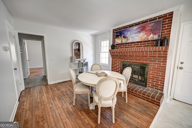 1202 Franklin Rd SW, Plainville, GA 30733 - dining space featuring a fireplace, wood finished floors, and baseboards
