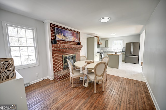 1202 Franklin Rd SW, Plainville, GA 30733 - dining space with a fireplace, light wood-style flooring, and baseboards