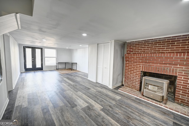 1202 Franklin Rd SW, Plainville, GA 30733 - unfurnished living room featuring heating unit, french doors, wood finished floors, baseboards, and a brick fireplace