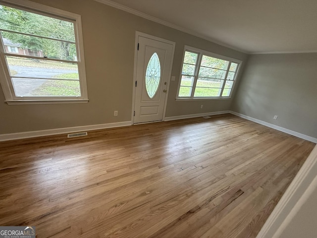 foyer with ornamental molding and light wood-type flooring