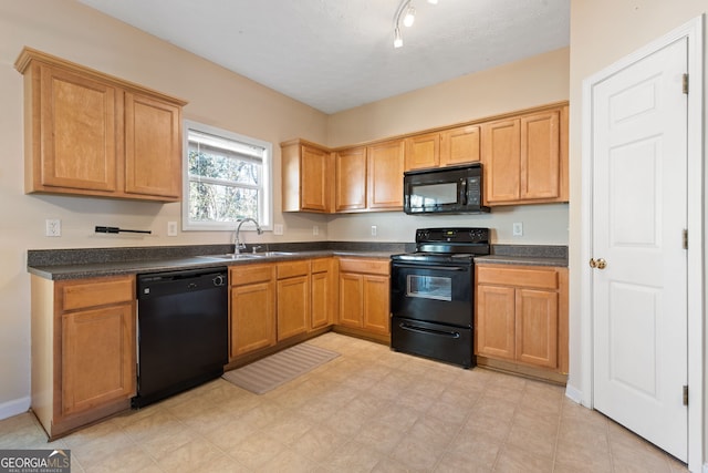 kitchen with sink, track lighting, and black appliances