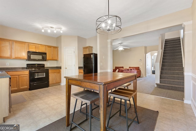 kitchen featuring ceiling fan, light tile patterned floors, hanging light fixtures, and black appliances