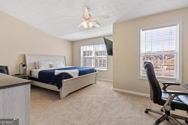 bedroom featuring multiple windows, ceiling fan, light colored carpet, and a textured ceiling