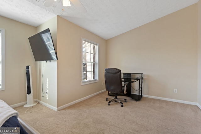 carpeted office space featuring ceiling fan and a textured ceiling