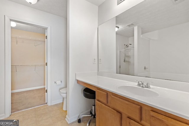 bathroom featuring walk in shower, vanity, a textured ceiling, and toilet