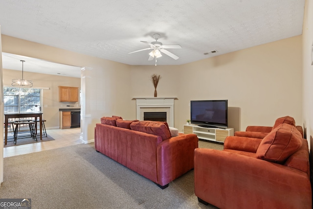 carpeted living room featuring ceiling fan and a textured ceiling