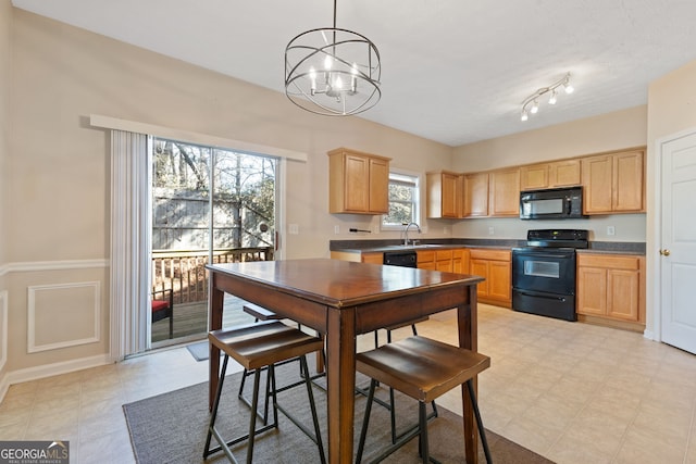 kitchen featuring sink, decorative light fixtures, a chandelier, light brown cabinets, and black appliances