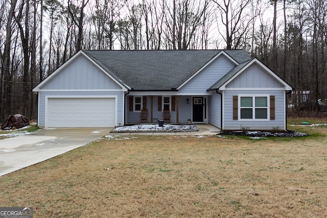 view of front of house featuring a porch, a garage, and a front lawn