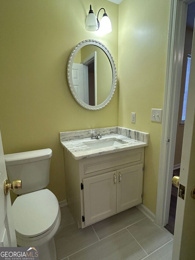 bathroom with vanity, toilet, and tile patterned flooring