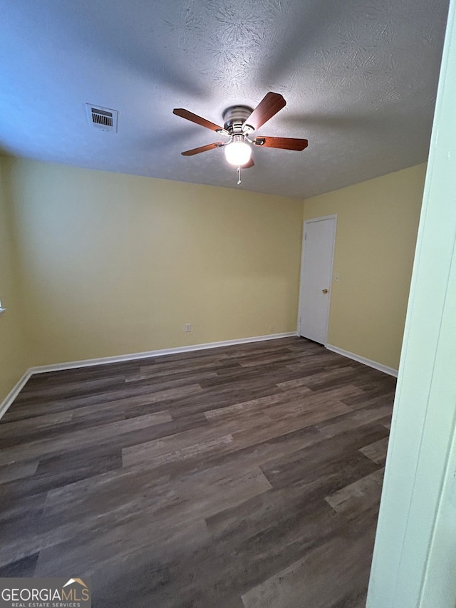 unfurnished room with ceiling fan, dark hardwood / wood-style floors, and a textured ceiling