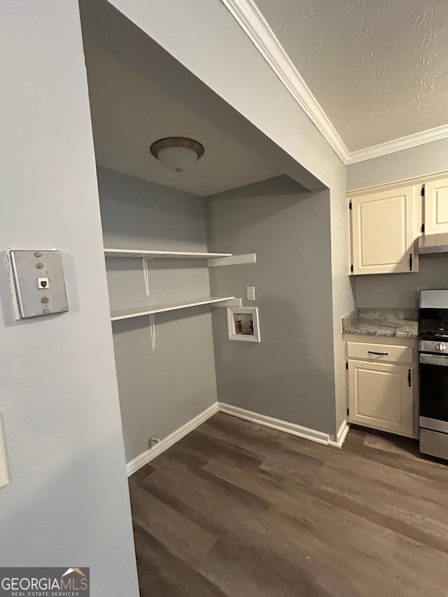 kitchen featuring white cabinets, crown molding, dark wood-type flooring, and stainless steel range oven