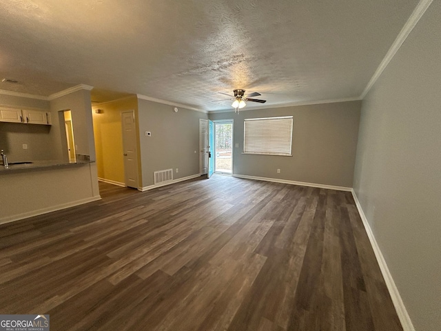 unfurnished living room featuring ornamental molding, dark hardwood / wood-style floors, sink, and a textured ceiling