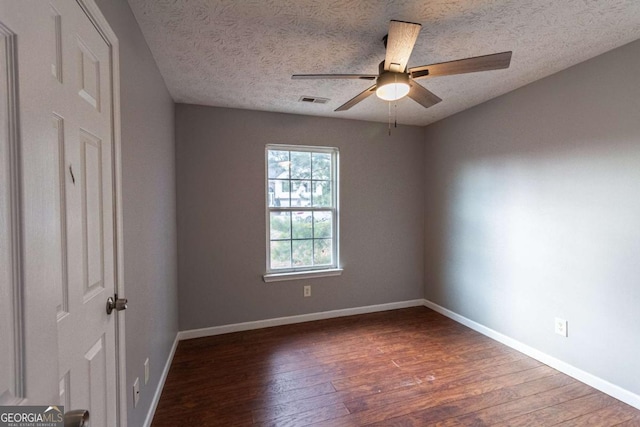 unfurnished bedroom with baseboards, a textured ceiling, visible vents, and wood finished floors