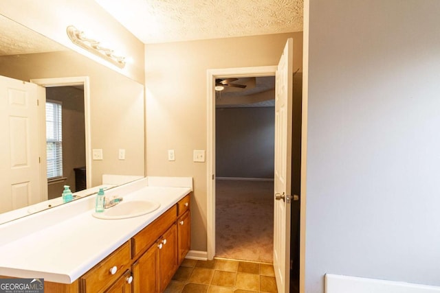 bathroom with a textured ceiling, vanity, and tile patterned floors