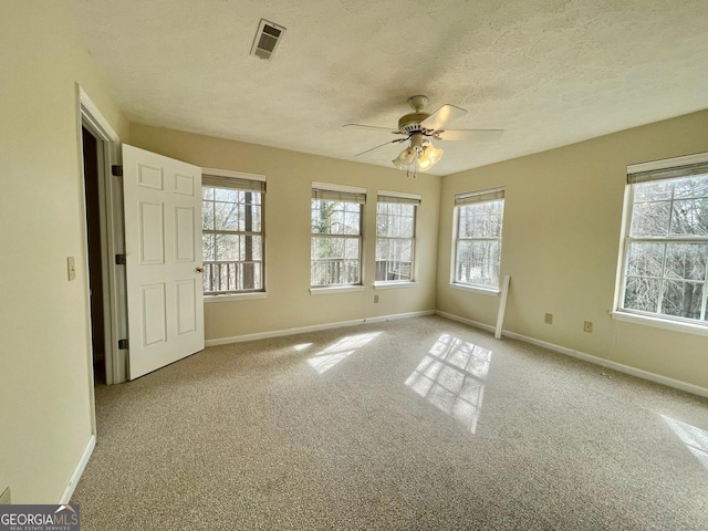 unfurnished bedroom with a textured ceiling, light colored carpet, and ceiling fan