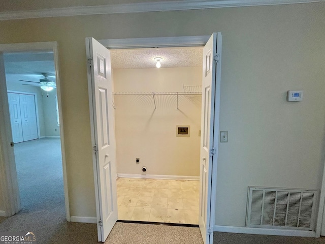 laundry room featuring light carpet, a textured ceiling, ornamental molding, ceiling fan, and washer hookup