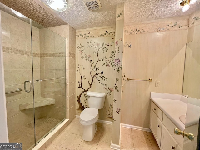 bathroom featuring tile patterned flooring, vanity, a textured ceiling, toilet, and walk in shower