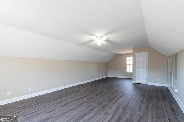 additional living space with lofted ceiling, ceiling fan, dark hardwood / wood-style flooring, and a textured ceiling