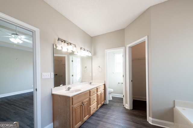 bathroom with toilet, a textured ceiling, vanity, ceiling fan, and hardwood / wood-style floors