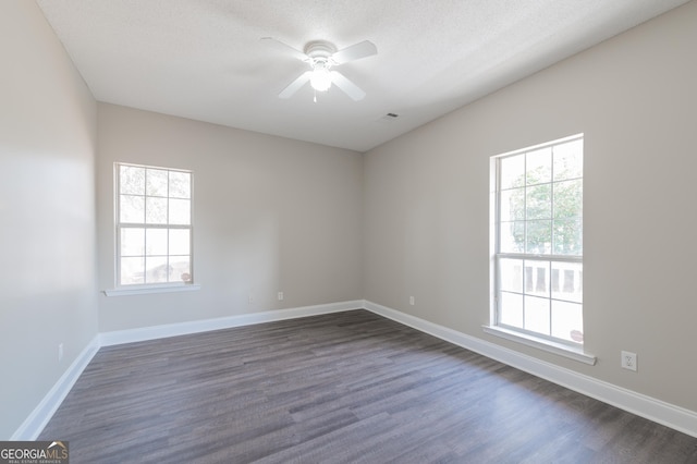 spare room with ceiling fan, a healthy amount of sunlight, dark hardwood / wood-style flooring, and a textured ceiling