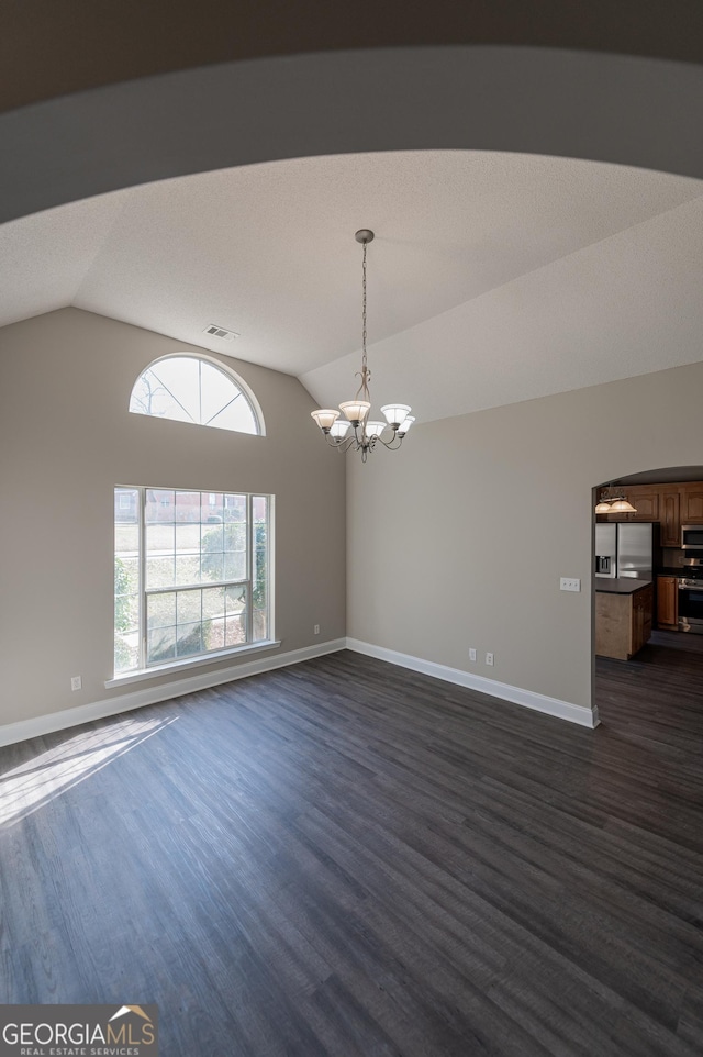 unfurnished room featuring vaulted ceiling, dark hardwood / wood-style floors, and an inviting chandelier