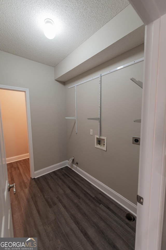 clothes washing area featuring dark hardwood / wood-style flooring, hookup for a gas dryer, washer hookup, electric dryer hookup, and a textured ceiling