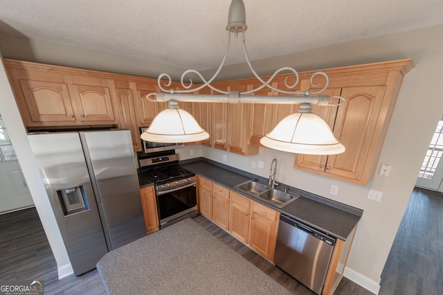 kitchen with decorative light fixtures, sink, dark hardwood / wood-style flooring, stainless steel appliances, and a textured ceiling