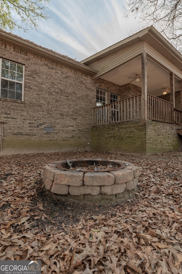 view of home's exterior featuring ceiling fan and an outdoor fire pit