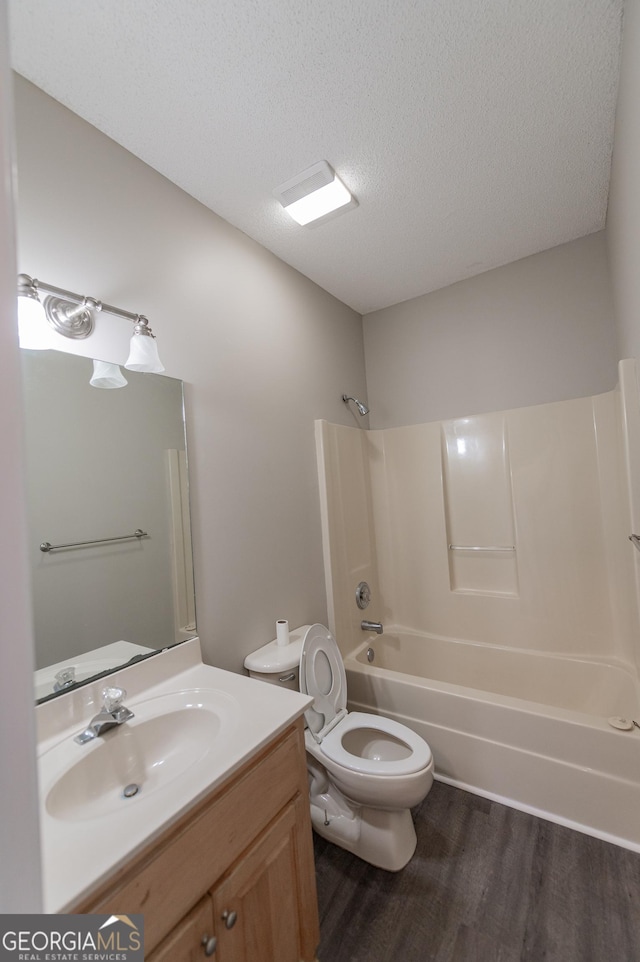 full bathroom with toilet, a textured ceiling, shower / bathtub combination, vanity, and hardwood / wood-style floors