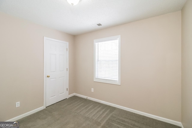 carpeted spare room featuring a textured ceiling