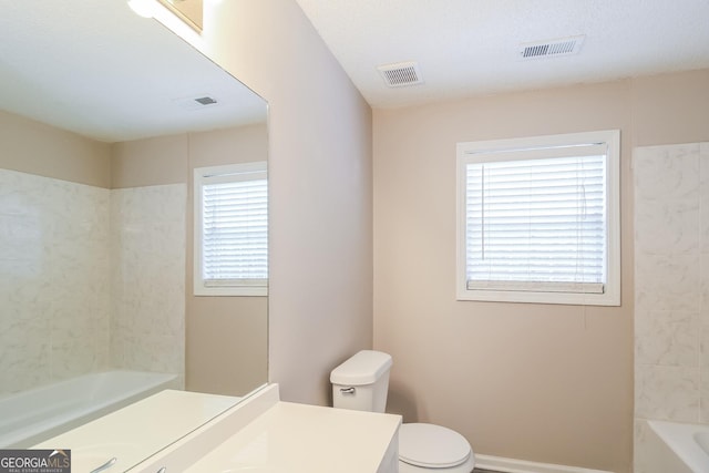 full bathroom featuring vanity, a textured ceiling, shower / washtub combination, and toilet