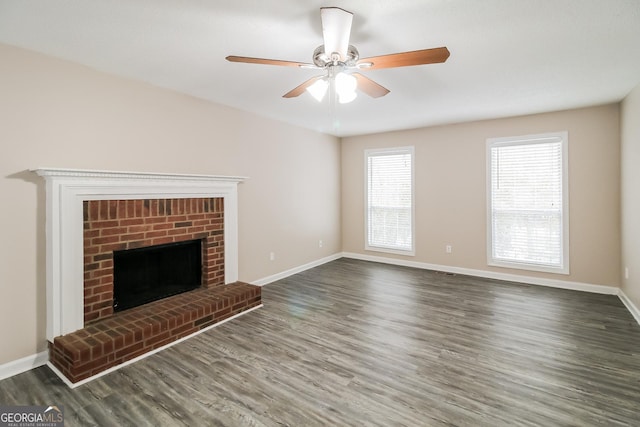 unfurnished living room featuring a fireplace, dark hardwood / wood-style floors, and ceiling fan