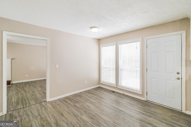 foyer featuring wood-type flooring and a textured ceiling