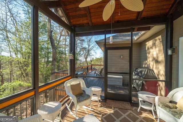 sunroom featuring lofted ceiling, wooden ceiling, and ceiling fan