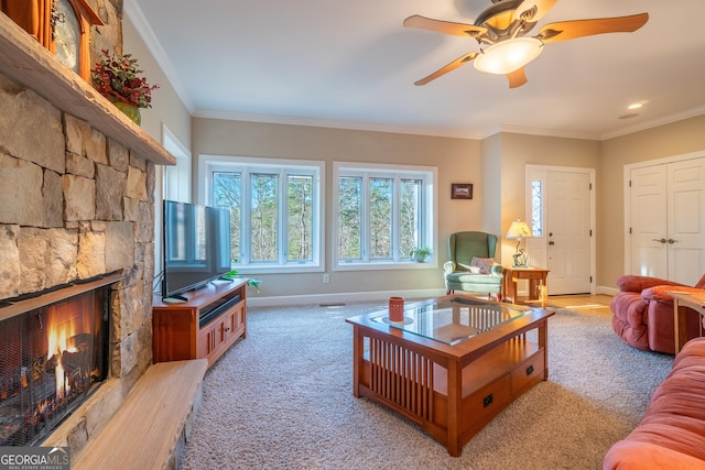 living room with ornamental molding, light colored carpet, ceiling fan, and a fireplace