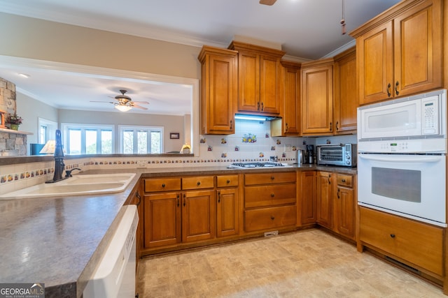 kitchen with sink, white appliances, decorative backsplash, and ceiling fan