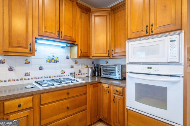 kitchen with tasteful backsplash and white appliances