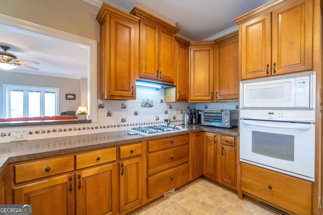 kitchen with backsplash, white appliances, ornamental molding, and ceiling fan