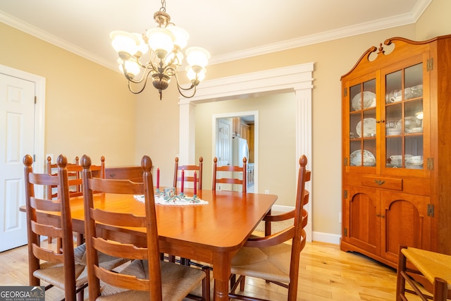 dining room featuring ornamental molding, a chandelier, and light hardwood / wood-style floors