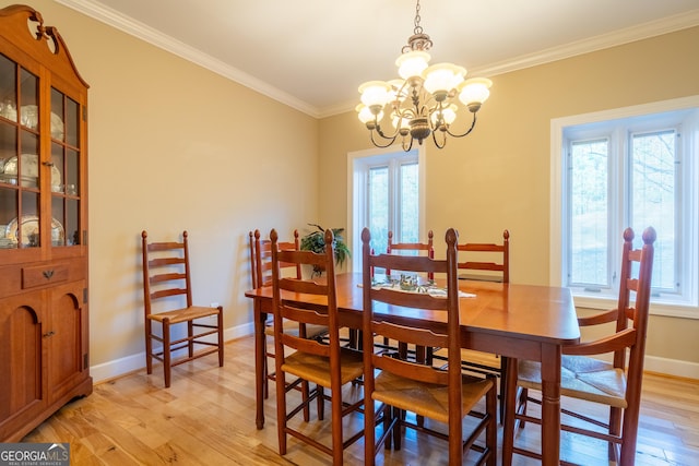 dining space featuring crown molding, a wealth of natural light, and light hardwood / wood-style floors