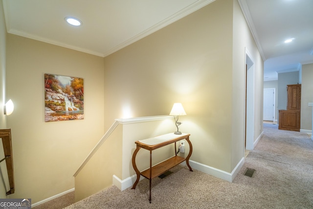 hallway with ornamental molding and light carpet