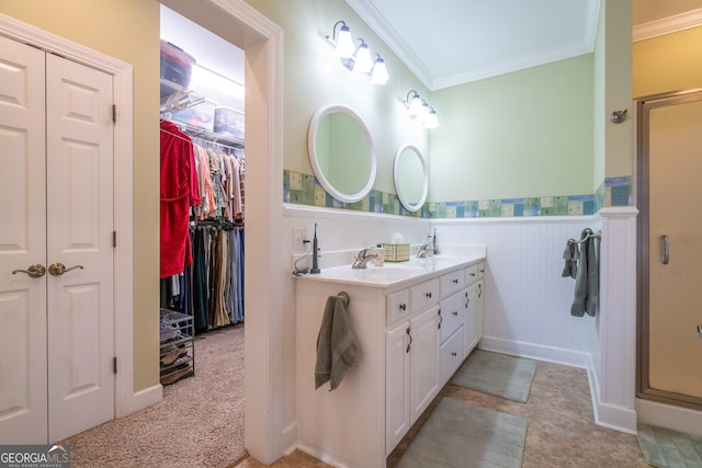 bathroom with crown molding, vanity, and a shower with shower door