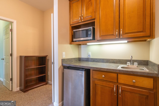 kitchen featuring light colored carpet, appliances with stainless steel finishes, and sink